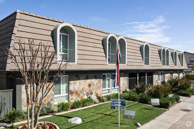 Two-story multifamily with mansard roof and well-maintained grounds